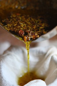 juliet Straining the herbal-infused oil